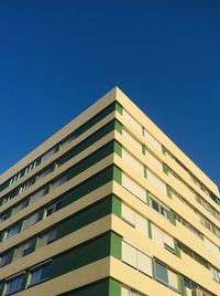 Low angle view of modern building against clear blue sky