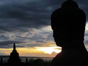 Silhouette of statue against sky during sunset