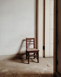 Empty chair against wall at home