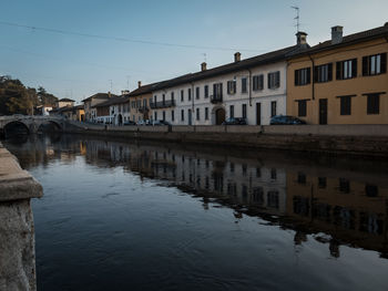 Reflection of buildings in water against clear sky