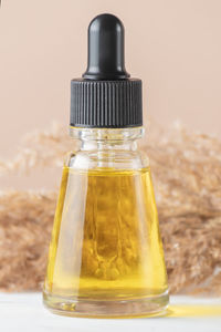 Natural beauty cosmetic product for skincare concept. glass dropper and dry reeds grass on beige 