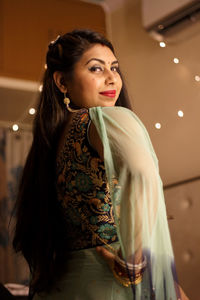 Portrait of woman wearing traditional clothing standing at home