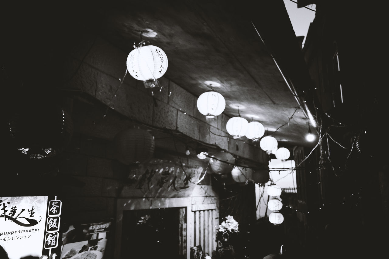 LOW ANGLE VIEW OF ILLUMINATED PENDANT LIGHTS HANGING AT RESTAURANT