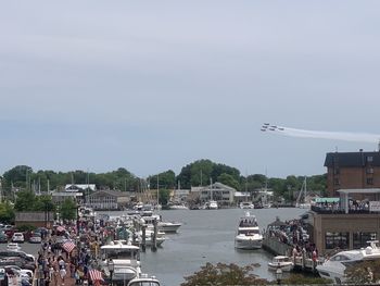 Sailboats in city against sky