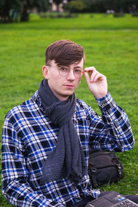 Portrait of young man sitting in park