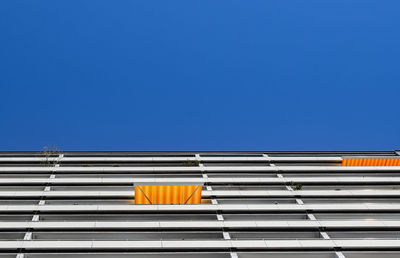 Low angle view of yellow building against blue sky