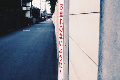 Close-up of road sign on wall in city