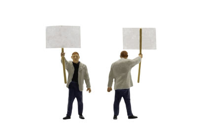 Rear view of friends standing against white background