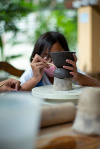 Midsection of woman drinking glass on table