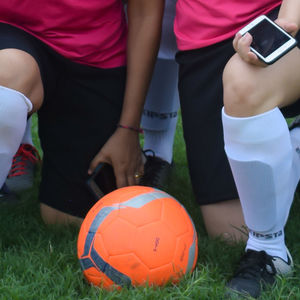 Low section of people playing soccer on field