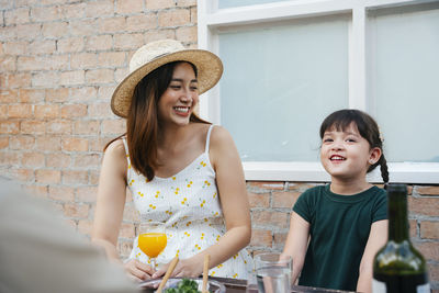 Portrait of a smiling young woman with drink on table