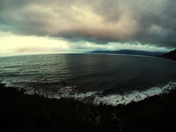 Scenic view of sea against storm clouds