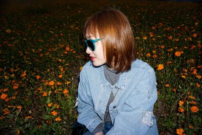 Woman wearing sunglasses while sitting on land at night