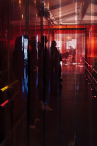 People seen through curtain standing in dark corridor