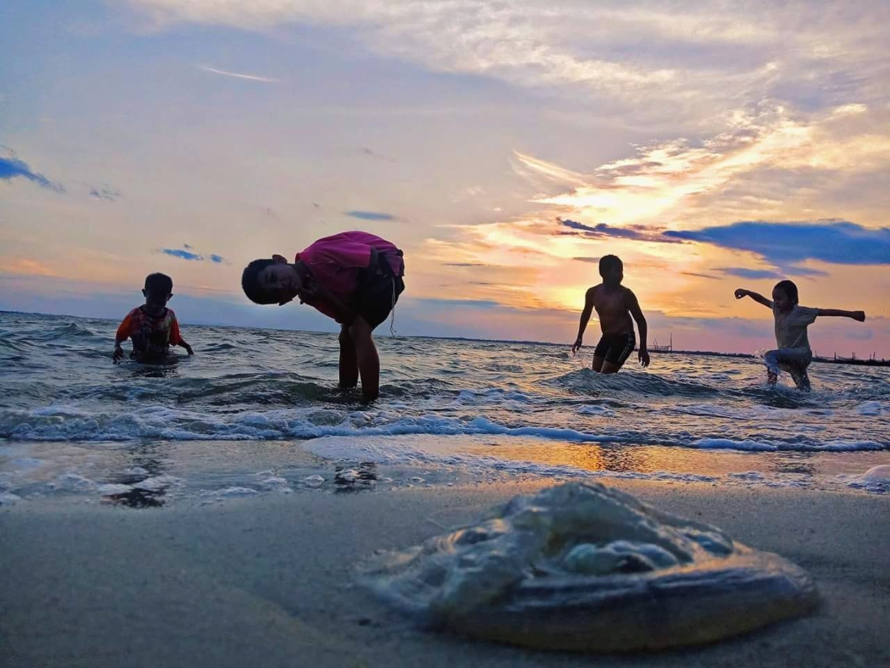 sky, sunset, water, real people, sea, group of people, leisure activity, men, lifestyles, land, beach, beauty in nature, cloud - sky, women, togetherness, people, sport, nature, child, horizon over water, outdoors