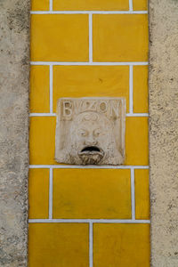 Close-up of yellow sculpture on wall