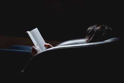 Rear view of woman reading book