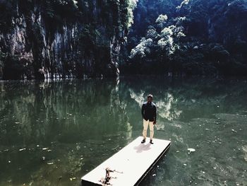 Man standing by lake against trees