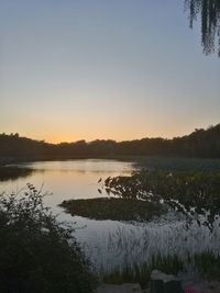 Scenic view of lake against sky at sunset