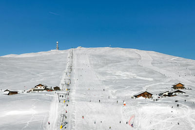 Skiing fun on corno del renon in the southtyrolean alps with view to the mountain huts in winter 