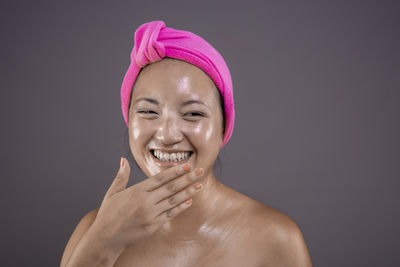 Close-up of shirtless young woman against black background