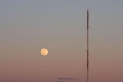 Low angle view of moon against clear sky at sunset