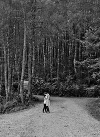 Rear view of woman walking in forest