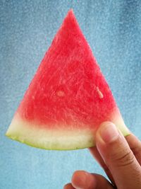 Cropped hand holding watermelon slice