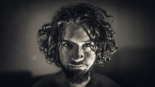 Close-up portrait of bearded man against wall