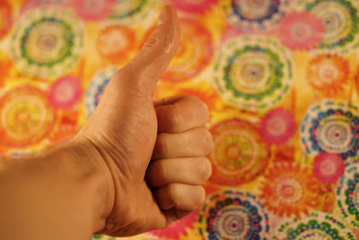 Cropped hand of man gesturing against wall