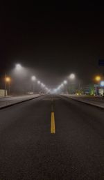 Light trails on street against sky at night