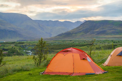 Tent on field by mountains against sky