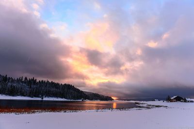 Scenic view of lake against sky at sunset