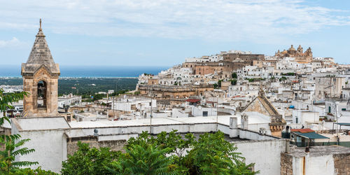 High angle view of townscape by sea against sky