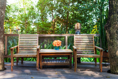 Empty bench and table against trees in yard