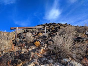 Stone wall on field against blue sky