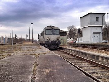 Railroad tracks against cloudy sky