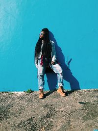 Woman standing against blue wall