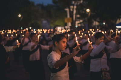 Group of people looking at illuminated city at night