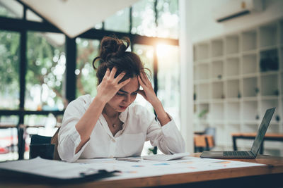 Young woman using mobile phone in office