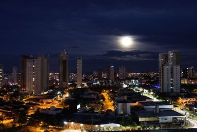 Illuminated cityscape against sky at night