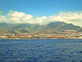 Scenic view of sea by city against sky