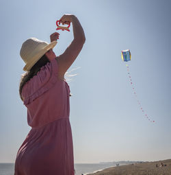 Low angle view of girl at beach against sky