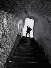 Silhouette man and woman standing in tunnel