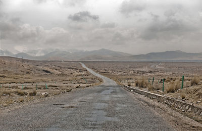 Scenic view of road by land against sky