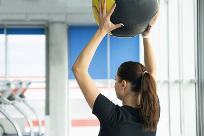 Rear view of woman exercising at gym