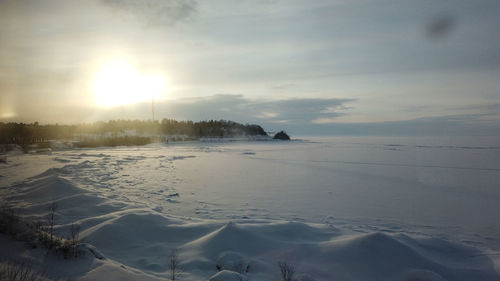 Scenic view of frozen lake against sky during sunset