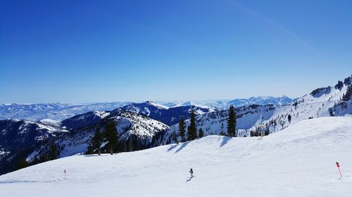 Scenic view of snowcapped mountains against blue sky