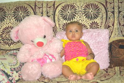 Cute baby girl sitting in toy at home