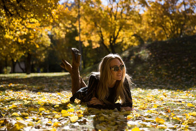 Woman looking away while lying at park